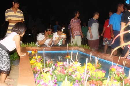 An evacuee couple prepares to loy (float) their krathongs in Sattahip, perhaps thinking of the final words to the Loy Krathong song, “As we push away we pray, we can see a better day.”